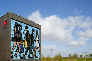 a mural of a group of people on a wall at citizenM Paris Charles de Gaulle Airport in Roissy-en-France