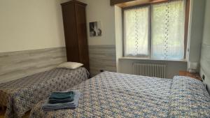 a bedroom with two beds and a window at Casa Domi in Sedrina