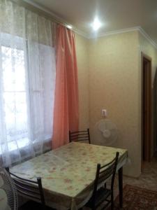 a table and chairs in a room with a window at Квартира on Vlasova 23 in Pyatigorsk