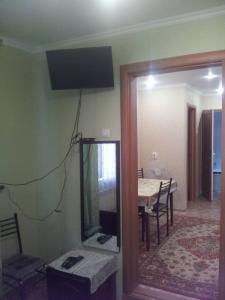 a room with a mirror and a dining room with a table at Квартира on Vlasova 23 in Pyatigorsk