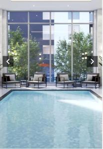 ein großer Pool in einem Gebäude mit Stühlen in der Unterkunft Modern Condo in Ottawa Downtown in Ottawa