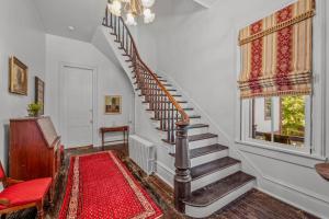 a staircase in a home with a red rug at The Manor - Historic Mansion, Wifi, Covered Porch, Screen Porch, King Bed, Walk to Spas, Shops & Restaurants in Berkeley Springs