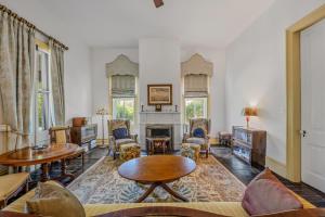 a living room filled with furniture and a fireplace at The Manor - Historic Mansion, Wifi, Covered Porch, Screen Porch, King Bed, Walk to Spas, Shops & Restaurants in Berkeley Springs