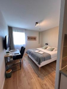 a bedroom with a bed and a desk and a television at Appart'Hotel - Gare TGV - Courtine - Confluence - 411 in Avignon +2 photos