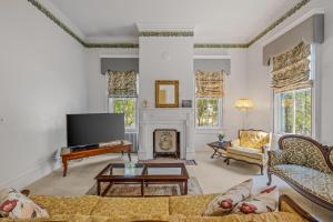 a living room with a fireplace and a tv at The Manor - Historic Mansion, Wifi, Covered Porch, Screen Porch, King Bed, Walk to Spas, Shops & Restaurants in Berkeley Springs +60 photos