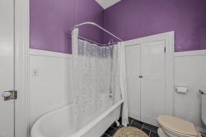 a purple bathroom with a toilet and a shower at The Manor - Historic Mansion, Wifi, Covered Porch, Screen Porch, King Bed, Walk to Spas, Shops & Restaurants in Berkeley Springs +60 photos