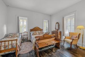 a bedroom with a bed and a desk and a piano at The Manor - Historic Mansion, Wifi, Covered Porch, Screen Porch, King Bed, Walk to Spas, Shops & Restaurants in Berkeley Springs
