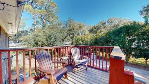 two chairs and a table on a deck at Beachbreak in Jekyll Island
