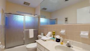 a bathroom with a shower and a toilet and a sink at Beachbreak in Jekyll Island +9 photos