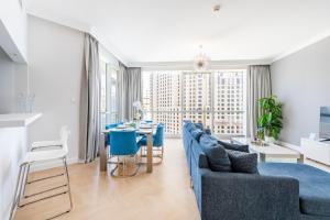 ein Wohnzimmer mit einem blauen Sofa und einem Tisch in der Unterkunft Al Bateen · Ultra Luxury JBR · Private Beach and Pool in Dubai