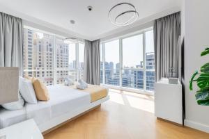 ein Schlafzimmer mit einem Bett und einem großen Fenster in der Unterkunft Al Bateen · Ultra Luxury JBR · Private Beach and Pool in Dubai + 88 Fotos