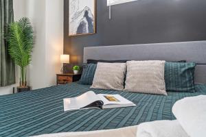 ein Schlafzimmer mit einem Bett, auf dem ein Buch liegt in der Unterkunft Luxe King 3BR Townhouse Mins to Uptown CLT in Charlotte