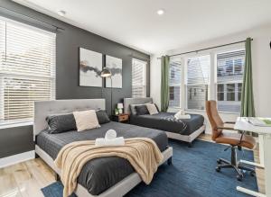 ein Schlafzimmer mit einem Bett, einem Schreibtisch und einem Stuhl in der Unterkunft Luxe King 3BR Townhouse Mins to Uptown CLT in Charlotte