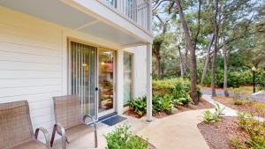 a house with two chairs on a porch at Villa 326 - A SHORE THING in Jekyll Island