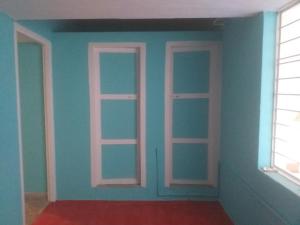 une pièce avec trois fenêtres et un mur bleu dans l'établissement Allô Gite, à Pondichéry