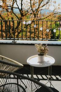 ein Tisch und Stühle auf einem Balkon mit Fenster in der Unterkunft LALA & DAUGHTERS Apartment in Vrnjačka Banja