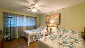 a bedroom with two beds and a ceiling fan at Very Nice Cottage in Jekyll Island