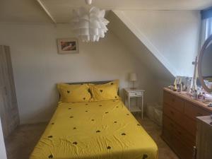 a bed with a yellow bedspread in a bedroom at Nice Apartment in Aalborg