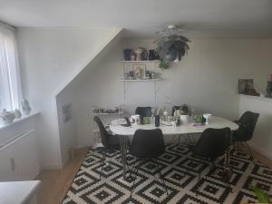 a dining room with a table and chairs on a rug at Nice Apartment in Aalborg