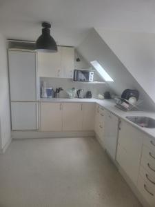 a kitchen with white cabinets and a sink at Nice Apartment in Aalborg