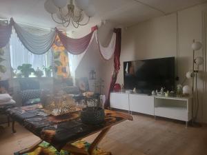 a living room with a table and a flat screen tv at Nice Apartment in Aalborg