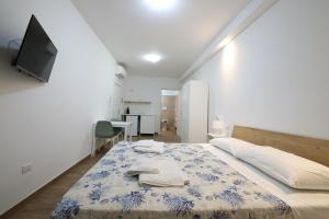 a bedroom with a bed with a tv on the wall at D&Dhome in Mola di Bari