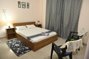 JorhatUptown Escape的带床和椅子的卧室