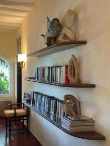a wall with shelves filled with books and shoes at Villa Elizabeth in Malindi