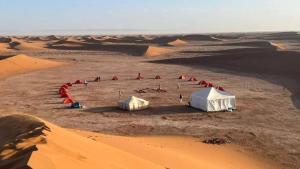 a group of tents in the middle of the desert at voyageur m'hamid Ghislaine in Tâlhâ