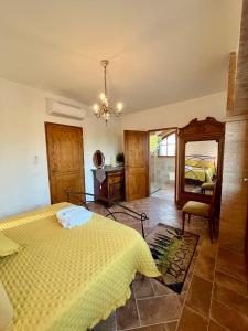 a bedroom with a yellow bed and a mirror at LA COLLINA DEI SAPORI Montepulciano in Montepulciano