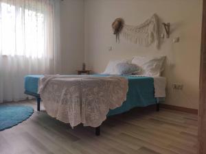 ein Schlafzimmer mit einem Bett mit einer blau-weißen Decke in der Unterkunft Tour House in Pedrouços