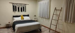 ein Schlafzimmer mit einem Bett mit gelben Kissen und einer Leiter in der Unterkunft Tour House in Pedrouços + 4 Fotos