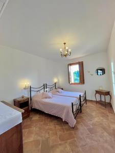 a bedroom with two beds and a chandelier at LA COLLINA DEI SAPORI Montepulciano in Montepulciano