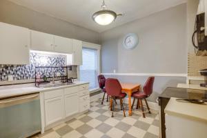 a kitchen with a table and chairs and a clock on the wall at 1 Mi to Lake Michigan! Urban Racine Apartment in Racine