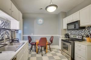 a kitchen with white cabinets and a table and chairs at 1 Mi to Lake Michigan! Urban Racine Apartment in Racine +16 photos
