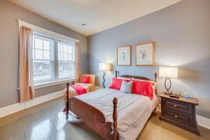 a bedroom with a bed with red pillows and a window at 1 Mi to Lake Michigan! Urban Racine Apartment in Racine