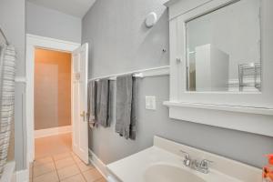 a bathroom with a sink and a mirror at 1 Mi to Lake Michigan! Urban Racine Apartment in Racine