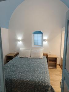 a bedroom with a bed and two tables and a window at Odysseas Traditional house in Mesaria