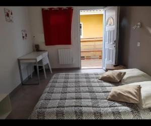 a bedroom with a bed and a desk and a window at Némo in Sauvagnon