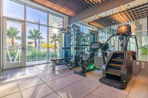 einen Fitnessraum mit Trainingsgeräten in einem Gebäude mit Fenstern in der Unterkunft @ Marbella Lane - Penthouse w/ City & Ocean Views in Long Beach