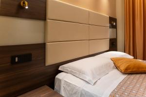 ein Schlafzimmer mit einem Bett mit großem Kopfteil in der Unterkunft Lepanto Central in Messina