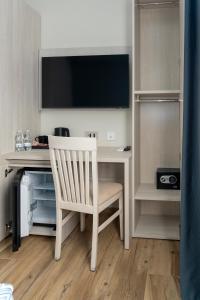 Cette chambre comprend un bureau avec une chaise et une télévision. dans l'établissement Lepanto Central, à Messina