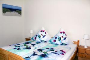 a bedroom with a bed with two pillows on it at Pension Nordsee in Norddeich