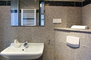 ein Badezimmer mit Waschbecken und Spiegel in der Unterkunft Pension Nordsee in Norddeich