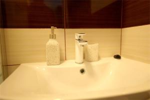 a bathroom sink with a bottle of soap on it at Hotel Mina in Craiova