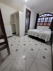 ein Schlafzimmer mit einem Bett und einem gefliesten Boden in der Unterkunft Hotel Silveira in Guarapari