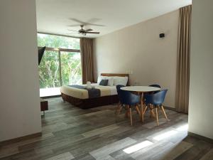 ein Schlafzimmer mit einem Bett und einem Tisch und Stühlen in der Unterkunft Hotel Piedra del Caribe Puerto Morelos in Puerto Morelos