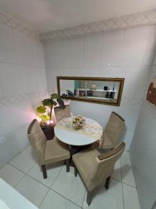 a dining room with a table and chairs and a mirror at Eds pousada in Juazeiro do Norte