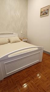 a white bed in a room with a wooden floor at Guest House Morais in Sintra