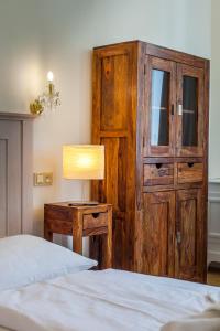 a bedroom with two beds and a wooden cabinet and a lamp at Masná - Old Town Residence in Prague